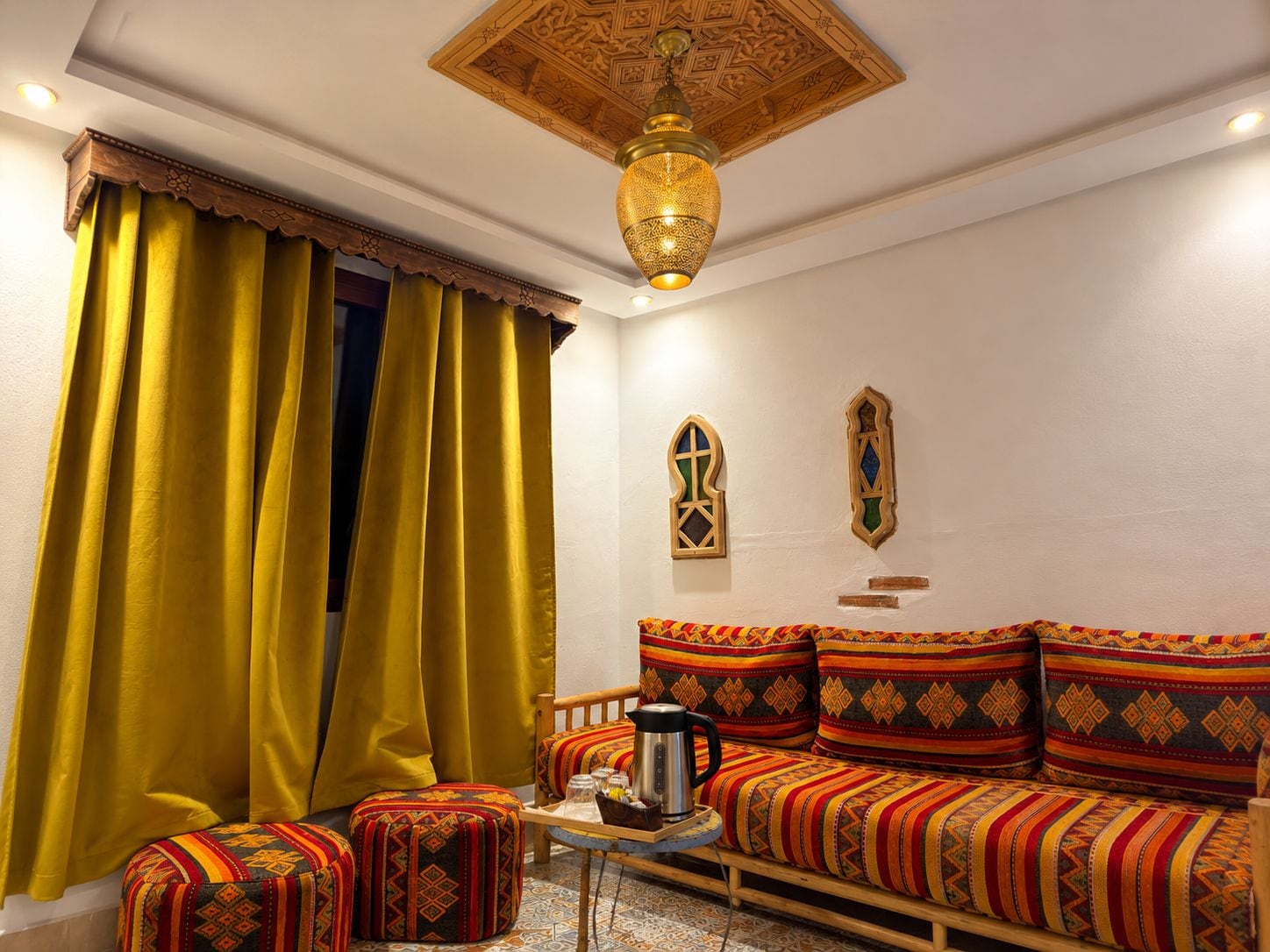 A room with a sofa, ottoman, and a coffee table.