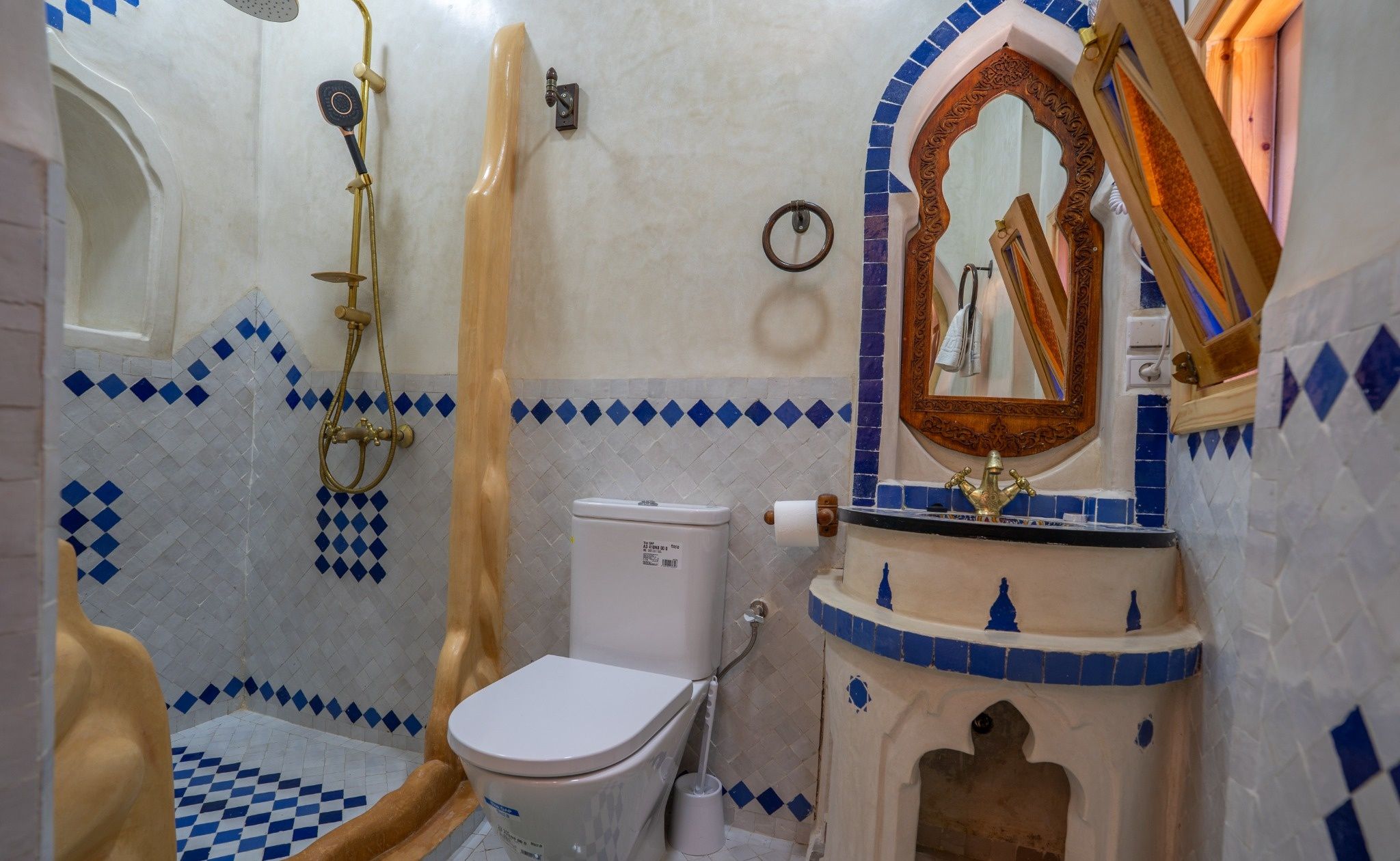A bathroom with a toilet, a shower, and a sink.