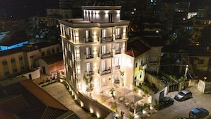 A multi-story building with balconies, outdoor seating, and a parking area. - Art Gallery Boutique Hotel (Durrës)