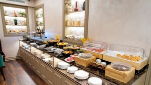 A buffet setup with various food items and a counter with plates. - Art Gallery Boutique Hotel (Durrës)