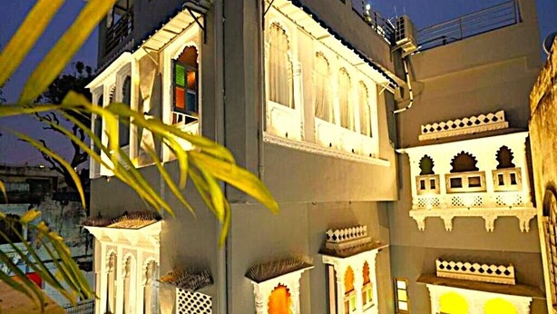 Un edifici de diverses plantes amb elements arquitectònics tradicionals, com ara finestres apuntades i balcons.