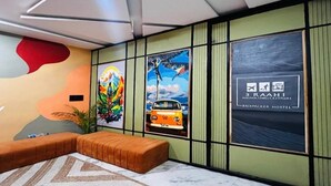 Interior modern d'un hostal amb un sofà, una catifes amb dibuixos i obra d'art a les parets.