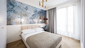 A modern bedroom with a large bed, a desk, and a large window with curtains. - Native Apartments Orawska 14 (Kraków)