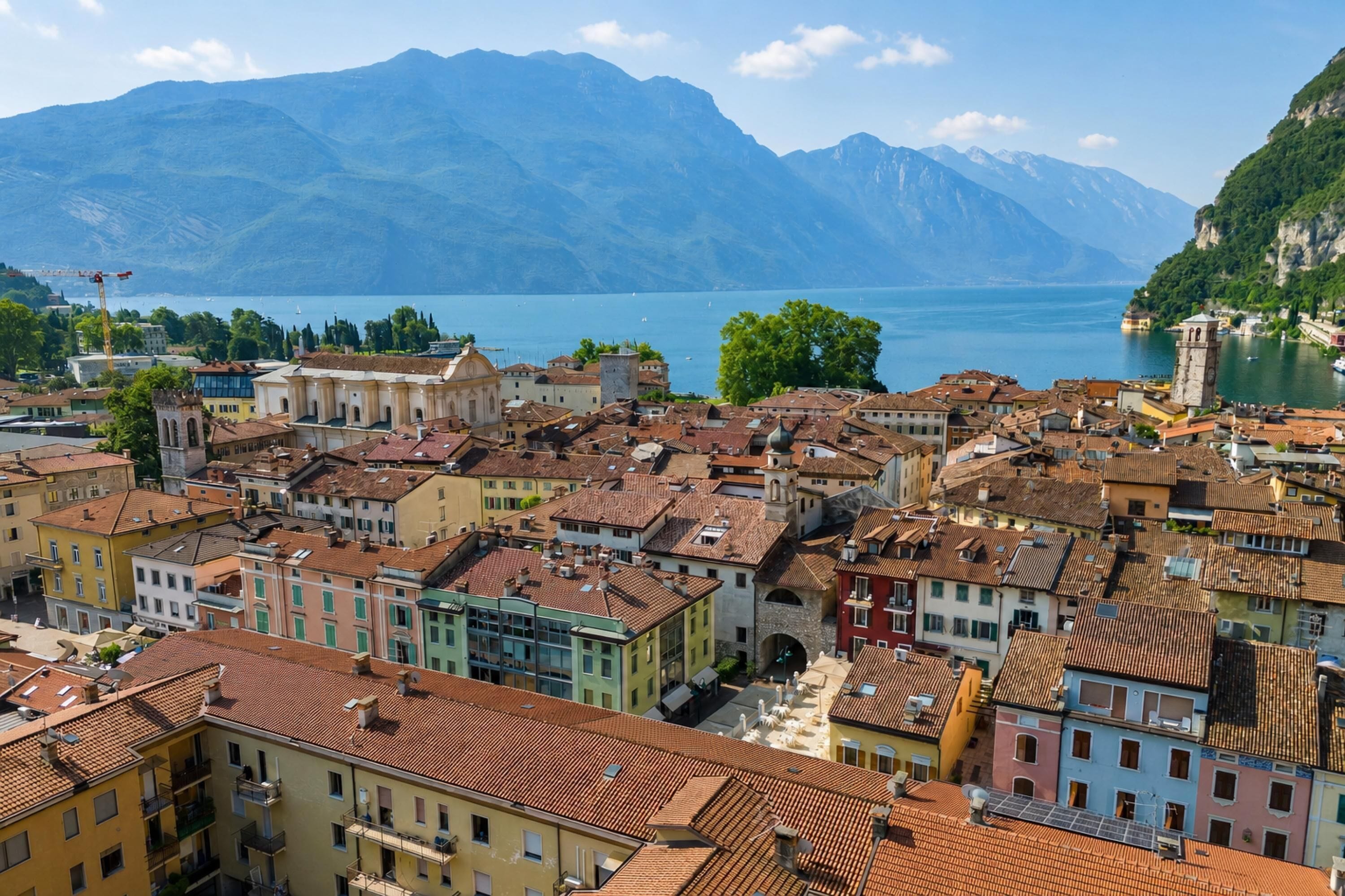 A coastal town with historic buildings, a waterfront, and mountains in the background.