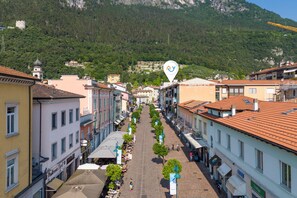 Una calle bordeada de edificios, algunos con balcones, y árboles a lo largo de la acera.
