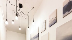 A hallway with wooden flooring, a wooden door, and a ceiling light fixture. - Native Apartments Skawińska 5 (Kraków)