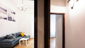 A modern living room with a sofa, a coffee table, and a chandelier. - Native Apartments Skawińska 5 (Kraków)