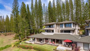 A two-story house with a large patio area, surrounded by a forest. - Spacious 2BR Best Ocean Views -Kapalua Golf Villas 11P 5-6 (Lahaina)
