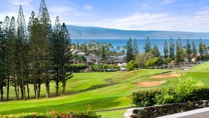 Ein Golfplatz mit Blick auf das Meer und einem Wohngebiet im Hintergrund.