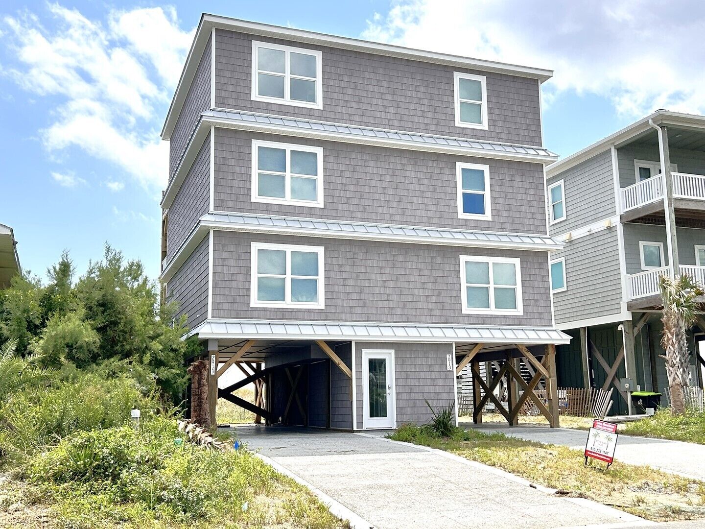 Un edificio residenziale a più piani con garage coperto e un balcone al piano superiore.