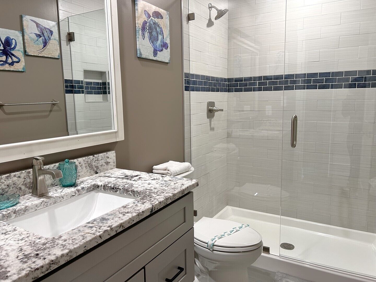 Une salle de bain avec un lavabo blanc, des toilettes et un espace douche.