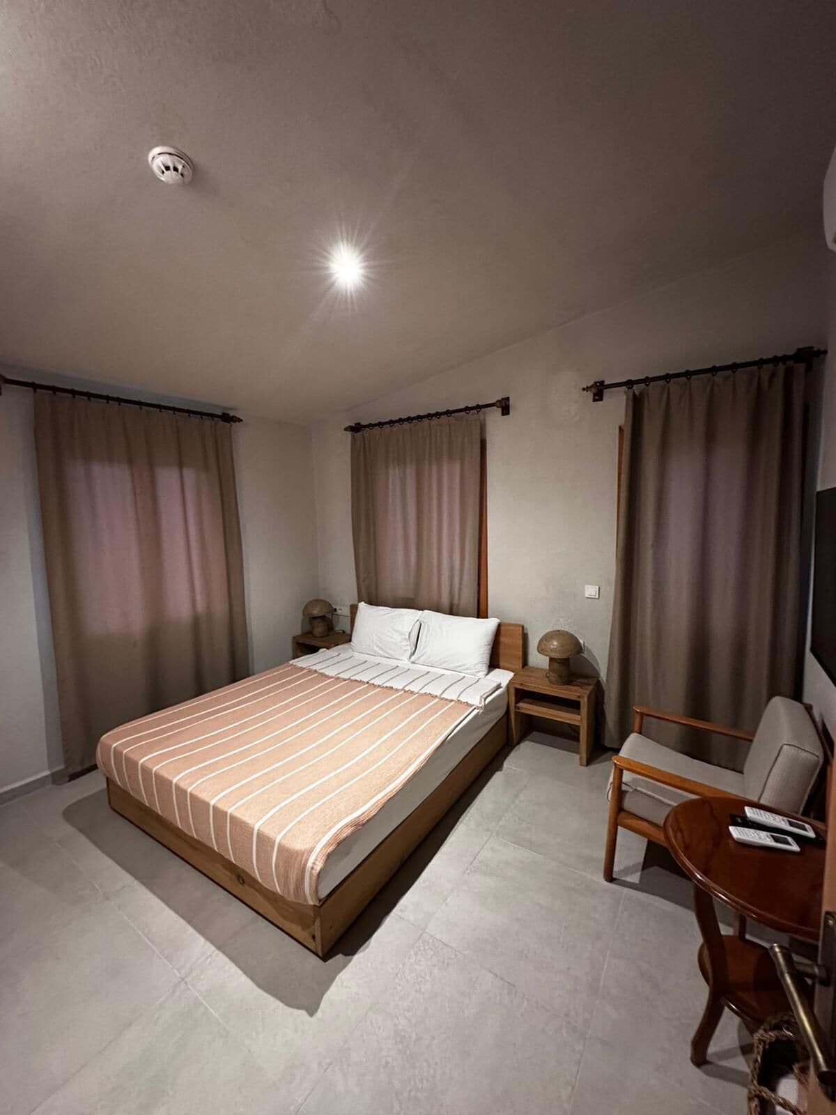 Una habitación de hotel con cama, escritorio, silla y televisión.
