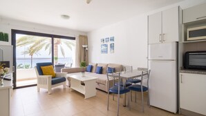 A modern apartment with a balcony, a dining area, and a kitchenette.