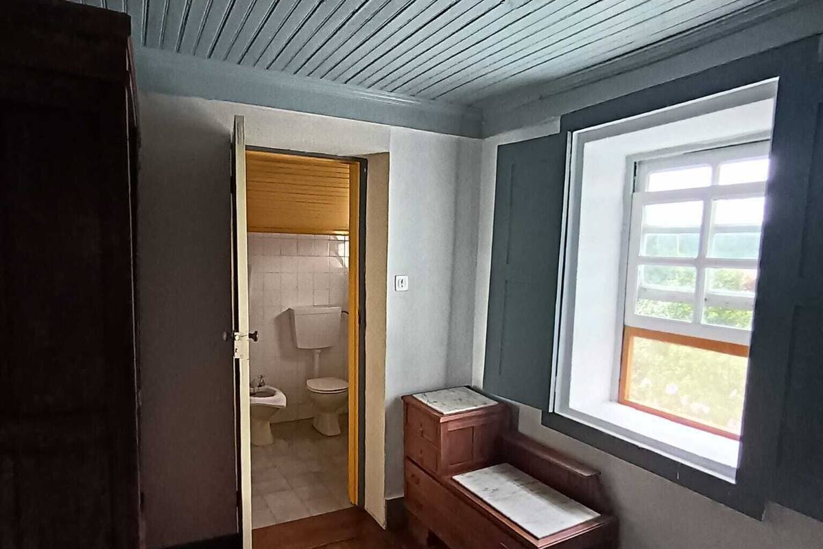 Une pièce dotée d’un plancher en bois, d’une fen être offrant une vue agréable, d’une armoire en bois et d’une porte donnant accès à une salle de bain.