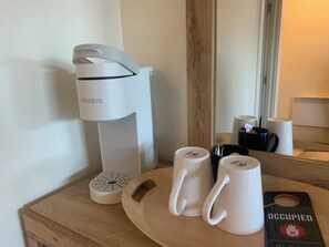 A coffee maker, two white mugs, and a plate with a tag on a wooden surface. - Downtown Friday Harbor! Newly Built! DS (Friday Harbor)