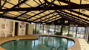 An indoor swimming pool with a covered roof, clear pool area, and a sign indicating no diving allowed. - Bay Tree cozy studio in Little River (Little River)