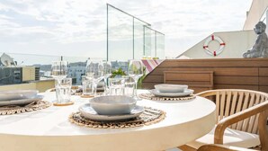 A round dining table set with plates, bowls, and glasses, surrounded by wooden chairs.