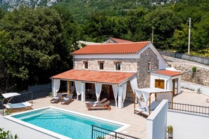 A two-story stone house with a swimming pool, outdoor seating, and a view of the surrounding forest. - Casa di Nika Stone Villa With Pool & Jacuzzi (Vinodol)