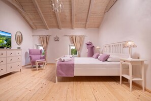 A bedroom with a bed, a chair, a dresser, a television, and a window with curtains. - Casa di Nika Stone Villa With Pool & Jacuzzi (Vinodol)