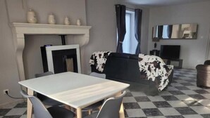 A dining area with a table and chairs, a fireplace, a sofa with a cowhide cover, and a checkered floor. - La Cadole House surrounded by a vineyard. Panoramic trails. (Baroville)