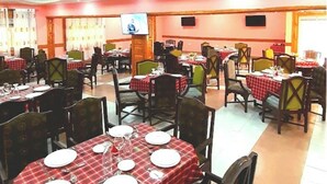 Een restaurant met meerdere tafels, elk gedekt met borden, bestek en glazen.