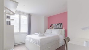 A bedroom with a bed, a chair, a desk, a radiator, and a window. - Chic 1BD Flat in the Heart of Islington! (Greater London)