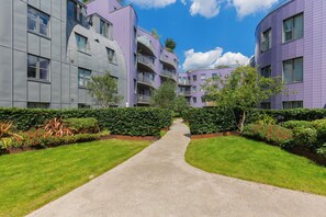 A pathway leading to a modern apartment complex with balconies and a well-maintained garden. - Chic 1BD Flat in the Heart of Islington! (Greater London)