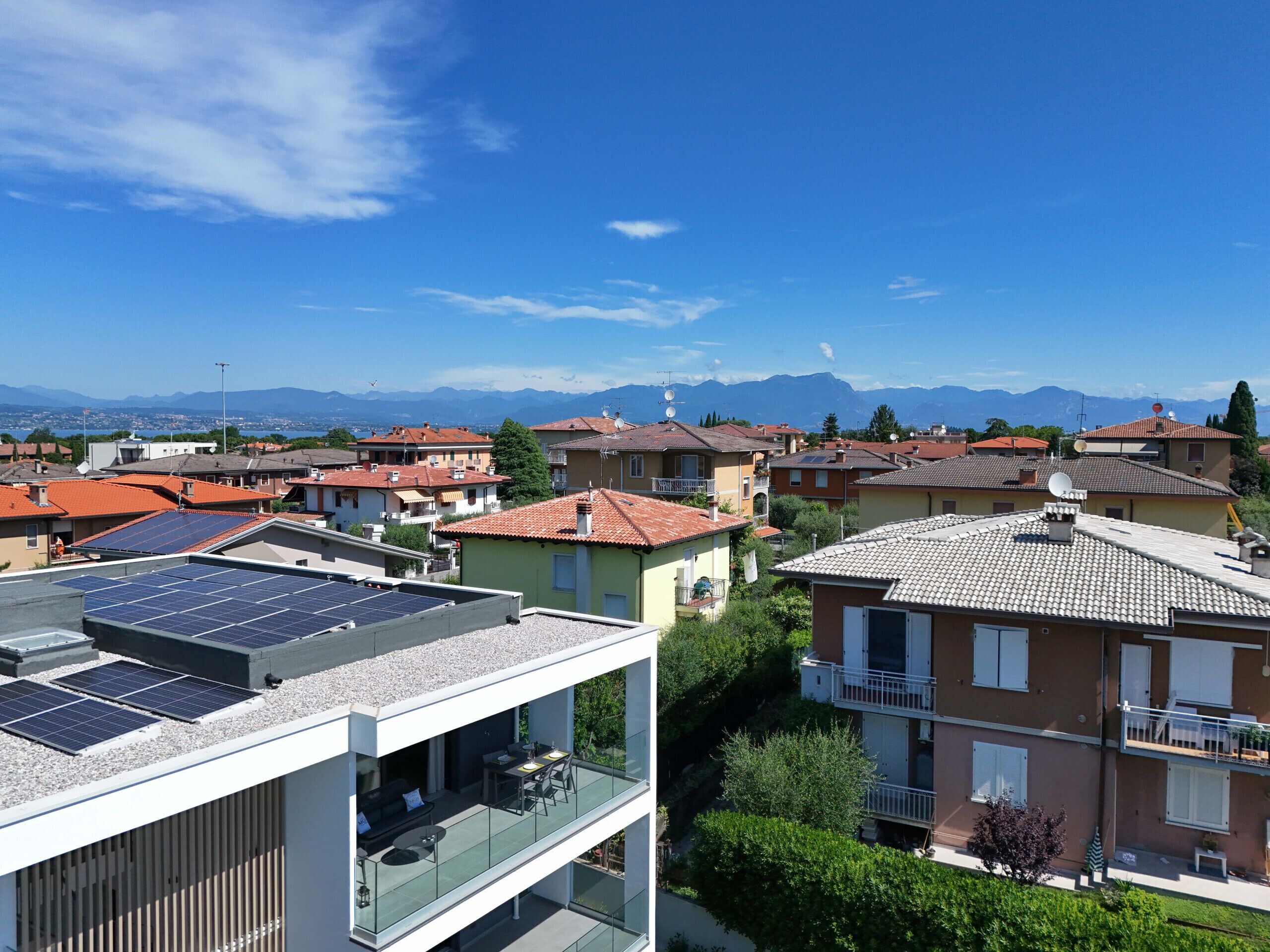 A residential area with houses featuring red-tiled roofs and solar panels.