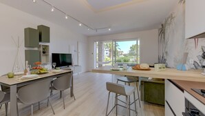 Una cocina moderna con comedor, ventanas amplias y vistas al exterior.