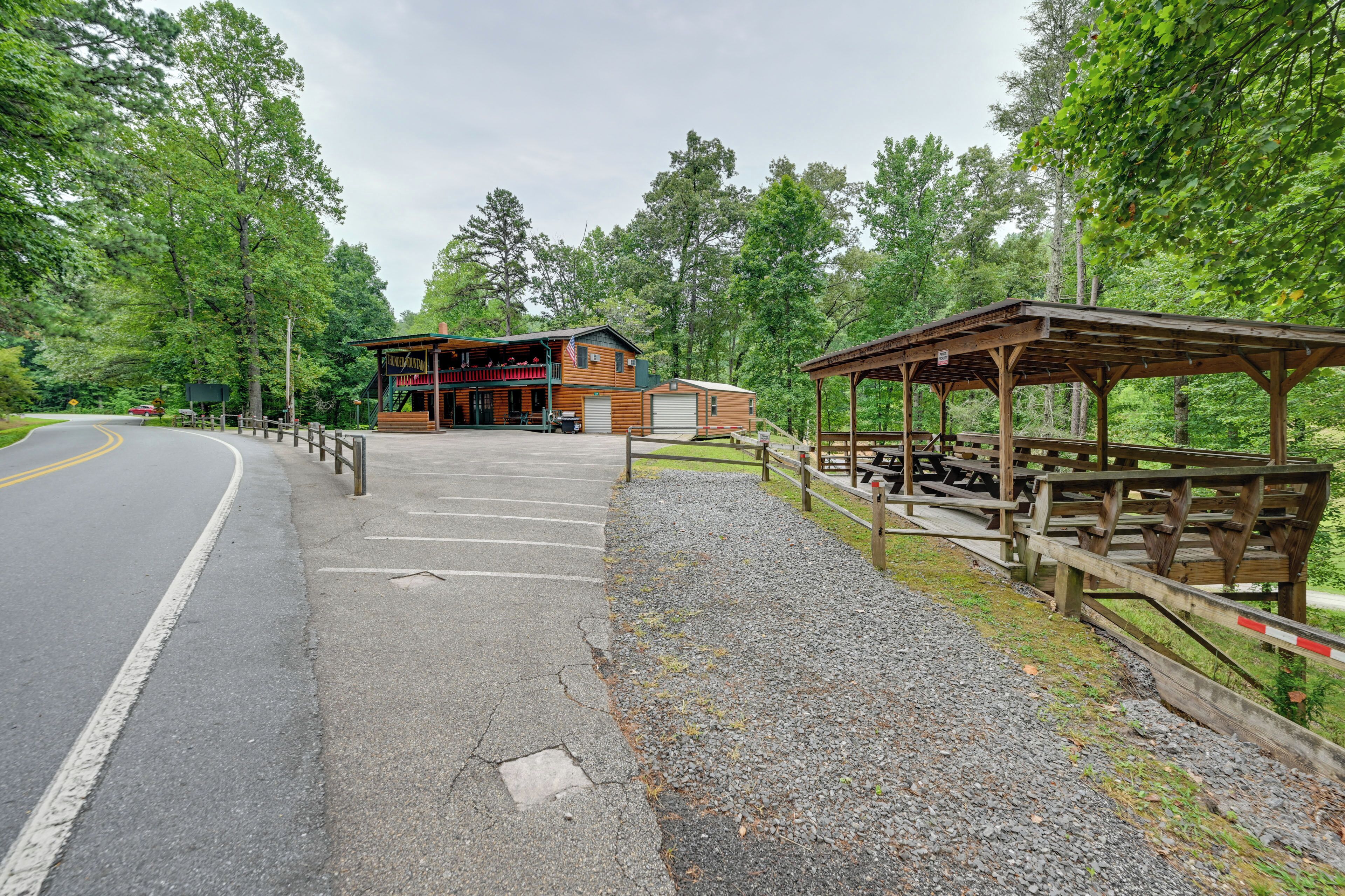 Een lodge met een overdekt picknickgedeelte en een gebouw met een veranda.