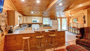 L’intérieur d’un chalet en bois comprend une cuisine, un coin bar et un espace détente avec des sièges.