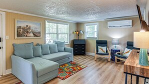 A living room with a light grey sofa, a colorful rug, a wooden coffee table, and a painting on the wall. - Middle Tennessee Cottage ~ 10 Mi to Dickson! (Bon Aqua)