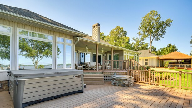 A deck with a hot tub, outdoor seating, and a covered area with a railing. - Lakefront Gem: Hot Tub, Boat Launch Near Greenwood (Cross Hill)