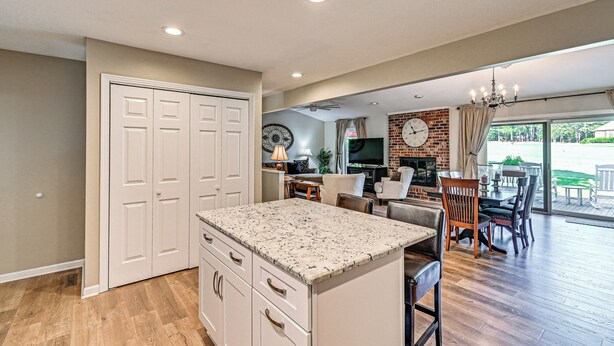 A spacious kitchen with a large island, a dining area with a brick wall, and a living room with a fireplace. - Charming Pinehurst Getaway w/ Golf Course View! (Pinehurst)