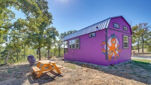 A purple building with a metal roof, a wooden picnic table, and a mural of an octopus. - Whimsical Cabin w/ Grill < 4 Mi to Lake Brownwood! (Brownwood)