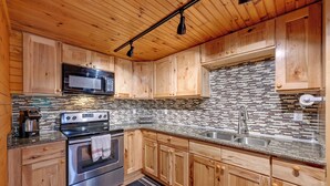 A kitchen with wooden cabinets, a stainless steel oven, a microwave, and a tiled backsplash. - 6 Mi to Town: Robbinsville Apt w/ Deck & Grill (Robbinsville)