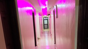 A long, narrow hallway with pink walls and a tiled floor. - Sky Park Lounge (Nairobi)