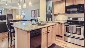 A modern kitchen with granite countertops, stainless steel appliances, and wooden cabinets. - Prime location Downtown Denver Cozy 2-bedroom condo in peaceful Denver (Denver)