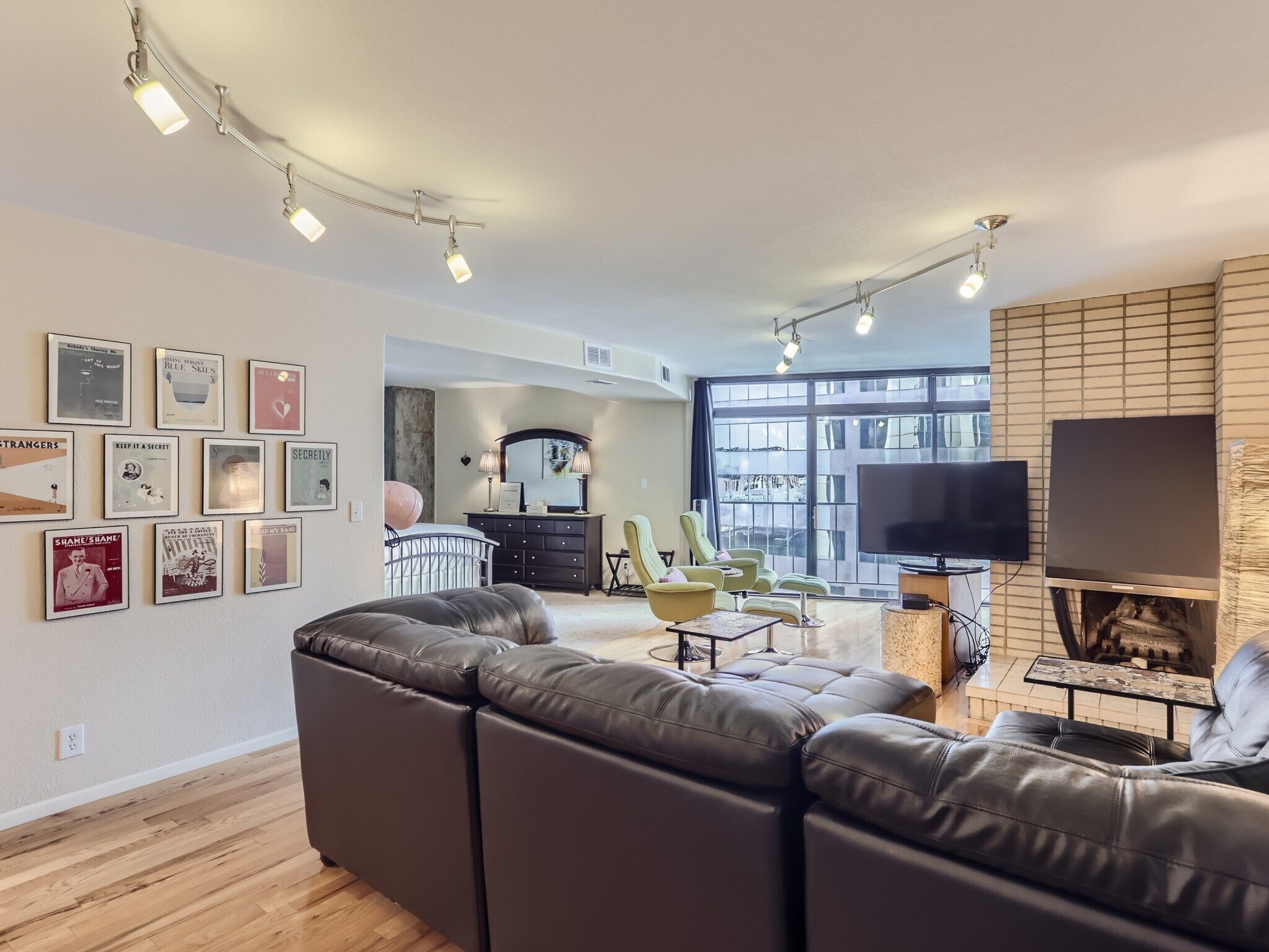 A modern living room with a sectional sofa, a flat-screen TV, and a fireplace.