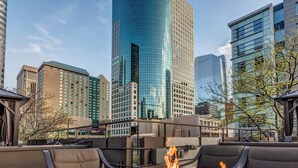 A rooftop terrace with a fire feature, surrounded by modern buildings and a clear sky. - Prime location Downtown Denver Cozy 2-bedroom condo in peaceful Denver (Denver)