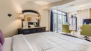 A hotel room with a large bed, a desk with a chair, a TV, a wardrobe, and a window with a view of buildings. - Prime location Downtown Denver Cozy 2-bedroom condo in peaceful Denver (Denver)