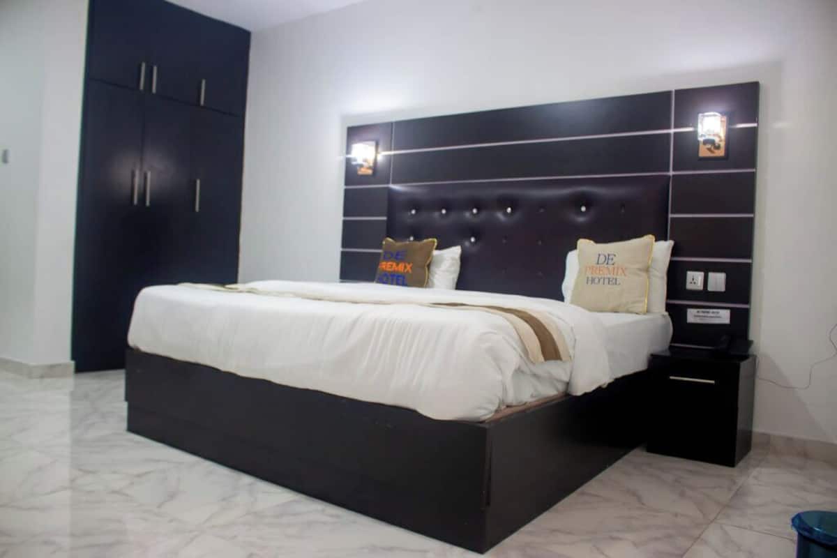 A bedroom with a large bed, dark headboard, and two bedside tables.