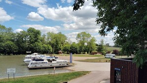 Un port de plaisance avec des bateaux amarrés, un espace d’accueil et un petit bâtiment.