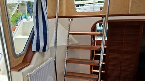 Eine enge Treppe mit Metallgeländern und Holzstufen, die zu einer höheren Ebene führt.