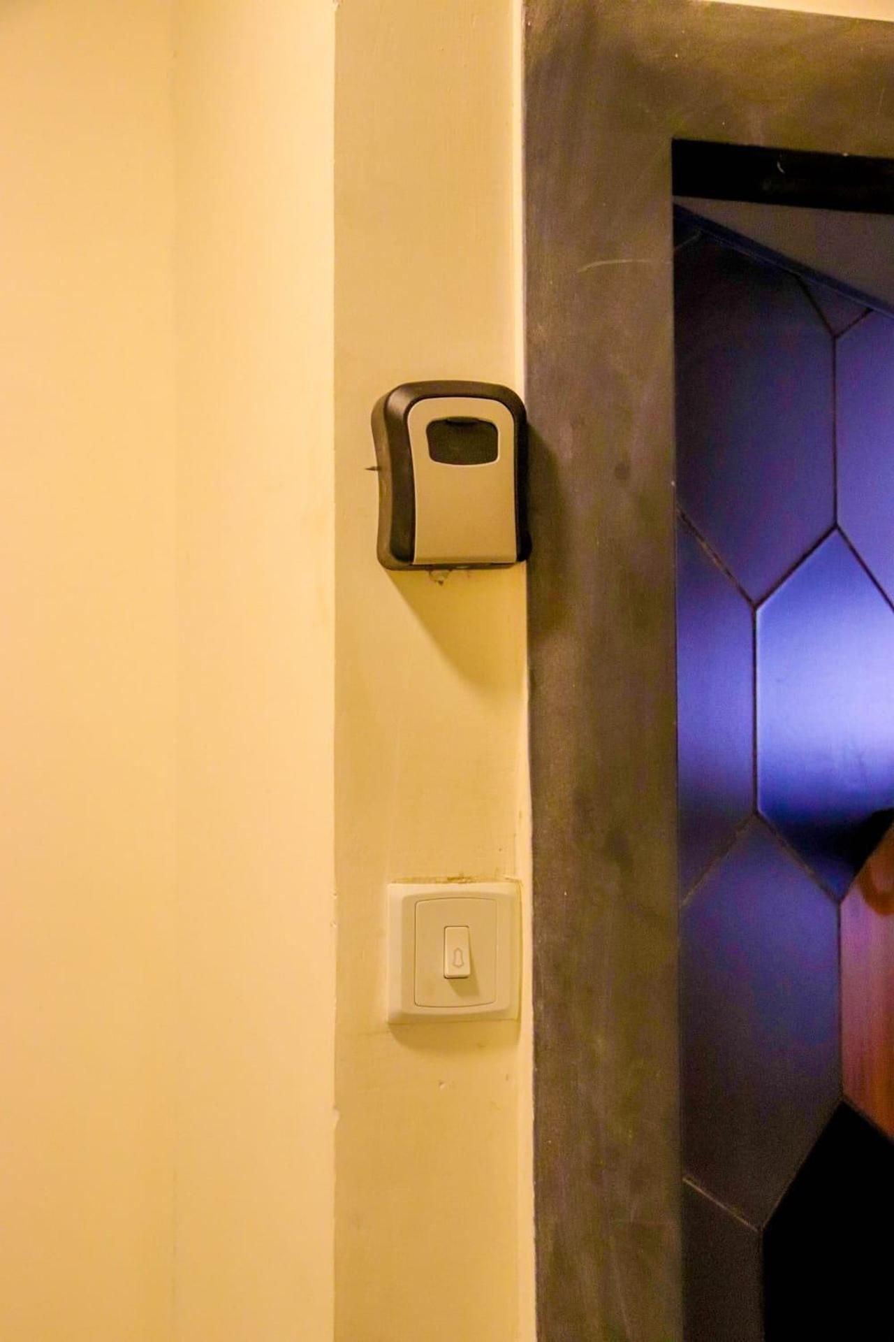A wall-mounted soap dispenser and a light switch.