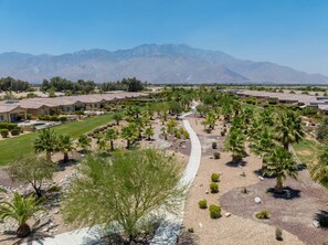 Una zona residencial con casas, un sendero y una cordillera al fondo.