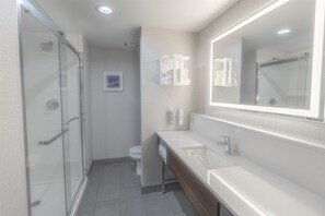 A modern bathroom with a glass shower enclosure, a white sink, and a large mirror. - Hampton Inn Santa Clarita-valencia (Valencia)