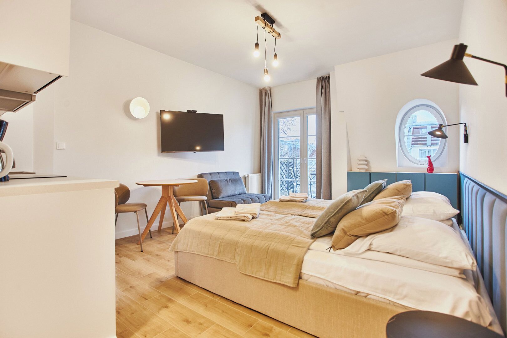 Ein modernes Schlafzimmer mit Bett, Schreibtisch, Stuhl, Fernseher und Fenster mit Blick.