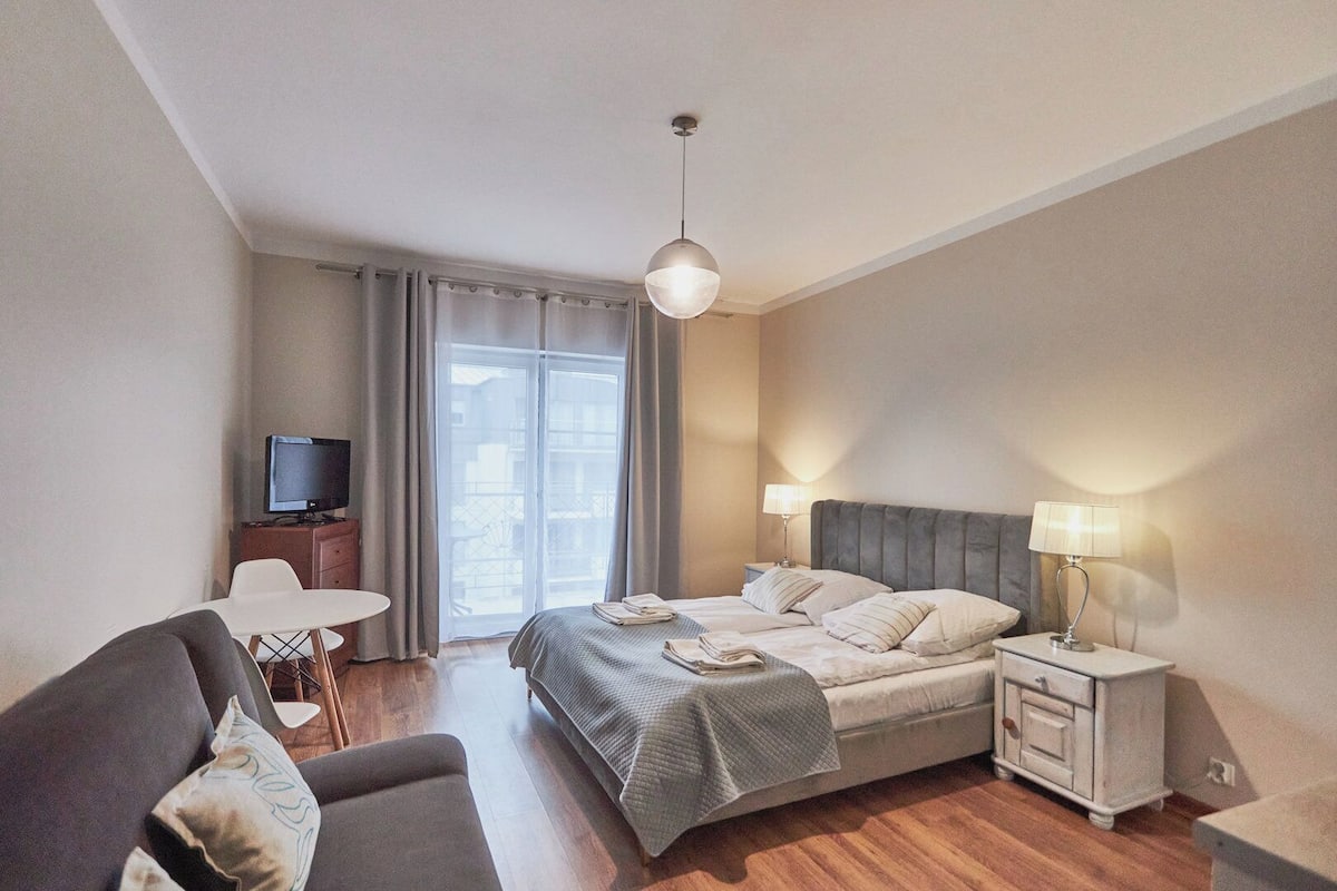 Une chambre d’hôtel comprenant un lit, des tables de chevet, une télévision, un bureau et une chaise.