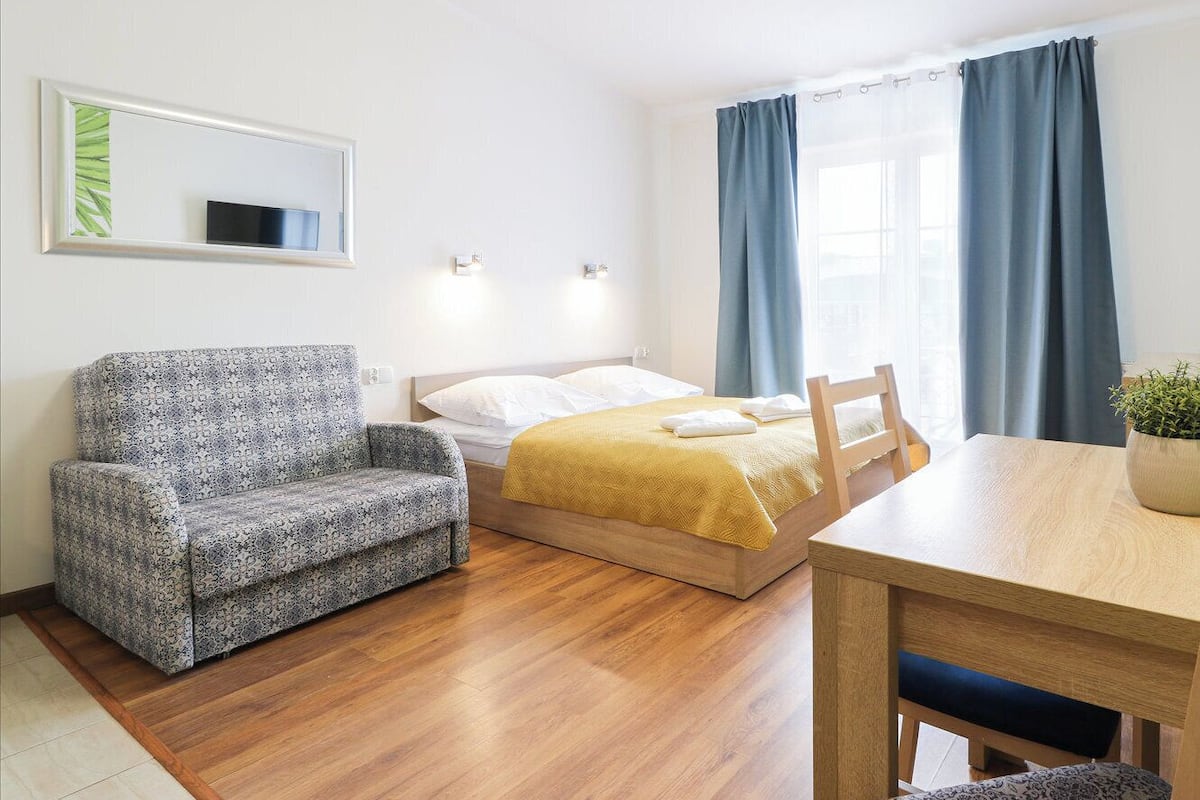 Une pièce comprenant un lit, un canapé, une table et une chaise.
